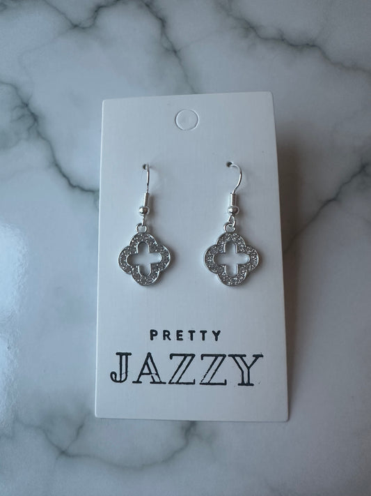 Close-up of silver earrings with an Alhambra-inspired outline design on earring backing board with Pretty Jazzy logo