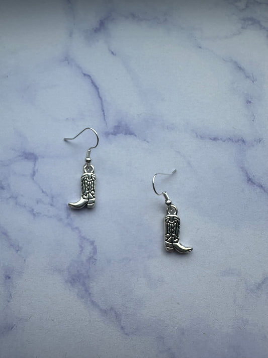 Country western earrings shaped like cowboy boots with silver details on silver plated hooks.