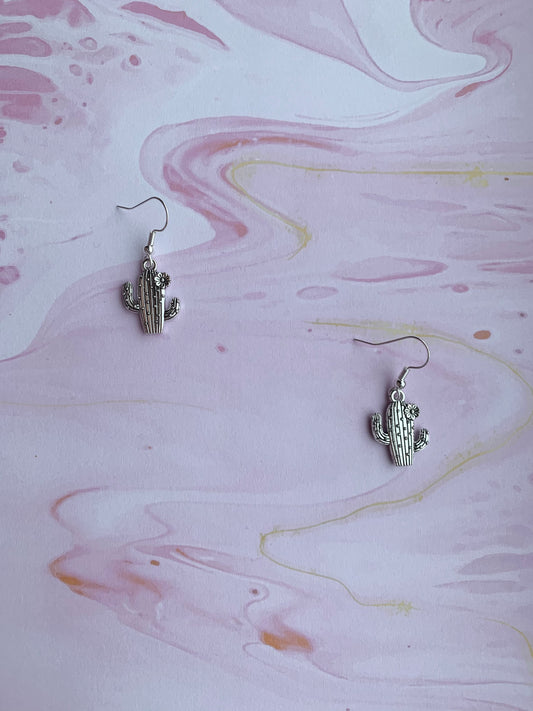 Dangly novelty earrings. Silver coloured alloy cacti charms with spikes and flower on silver plated hooks. Cheap cute earrings.