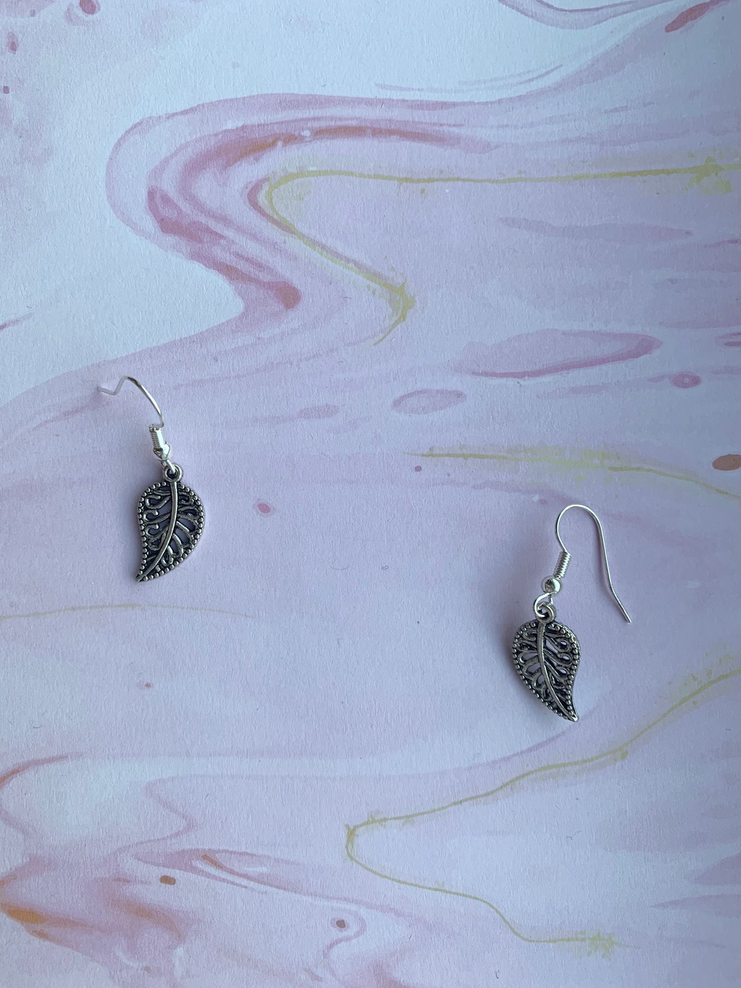 Silver coloured decorative leaf outline charm on silver plated hooks earrings. leaf earrings. nature earrings. dangle earrings.