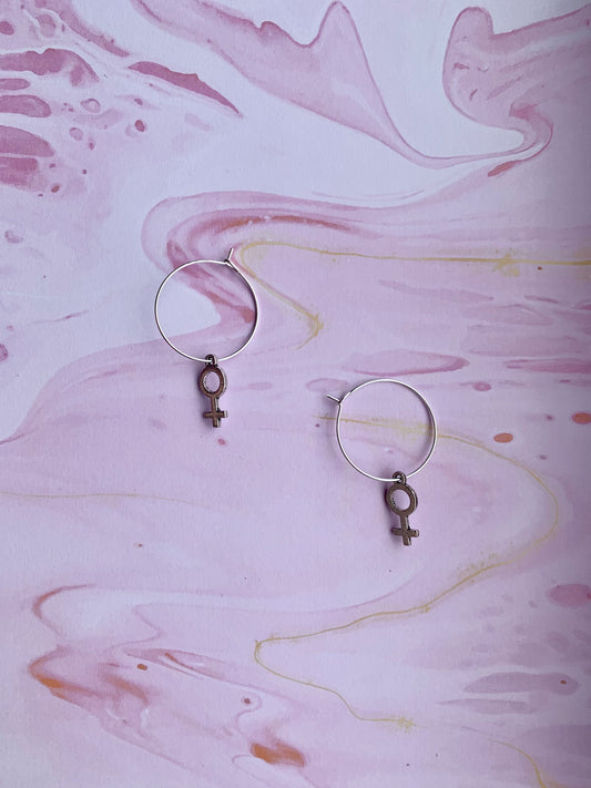 Silver coloured alloy female symbol charms on silver plated hoops. female earrings. feminist earrings. girl power. women power. earrings for women. earrings for girls.