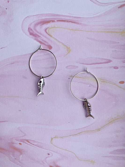 Alloy silver coloured fish skeleton charm on silver plated hoops. dangle earrings. goth earrings. bone earrings. hoop earrings.