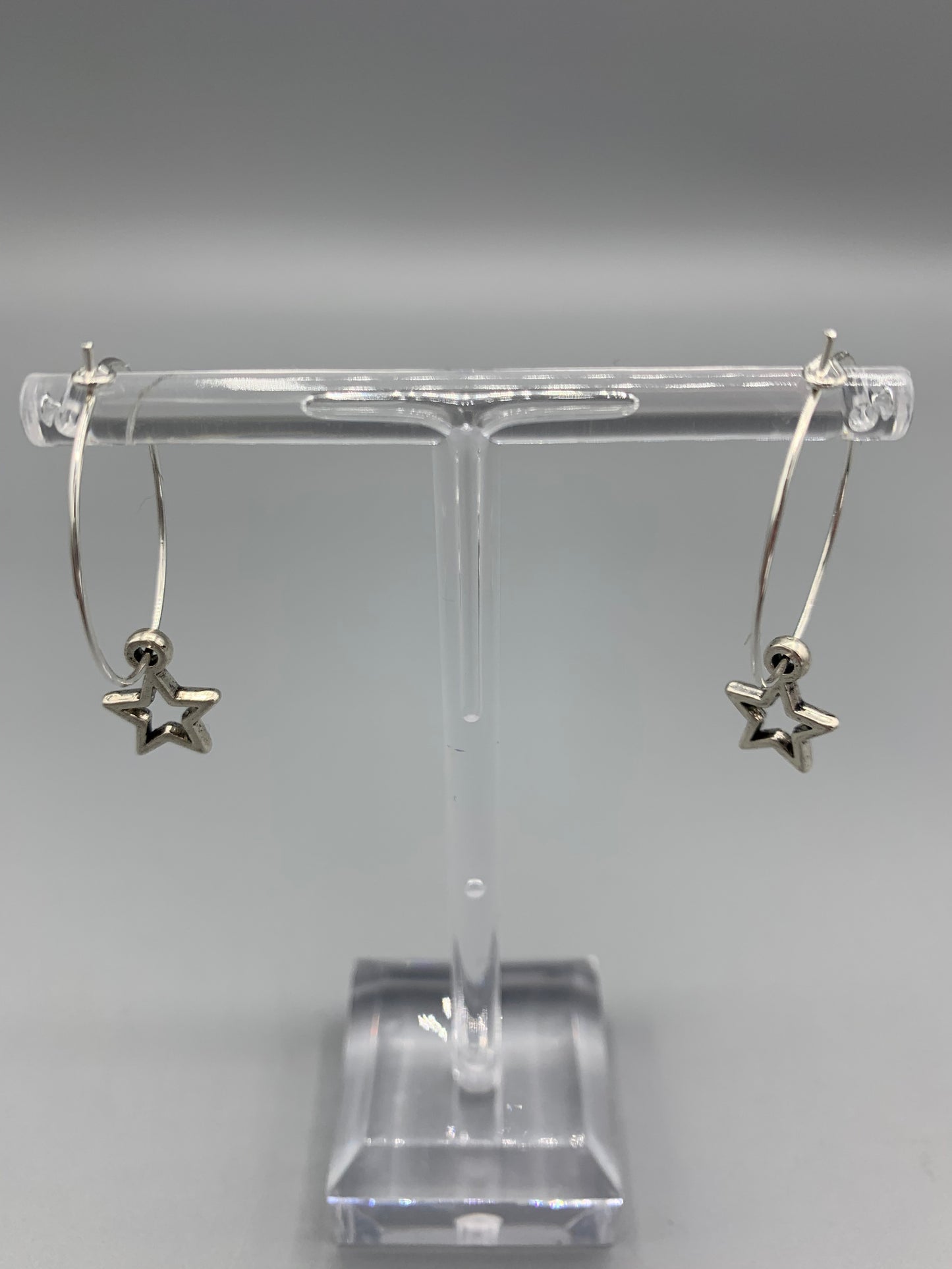 Star earrings. alloy silver coloured star hollow outline charm on silver plated hoops. pretty earrings. hoop earrings