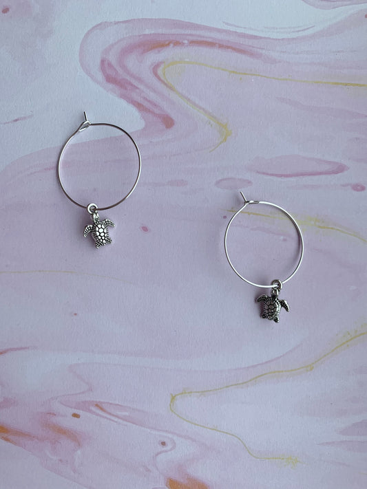 Cutest tiny turtle silver coloured alloy charm on silver plated hoops. hoop earrings. silver earrings. turtle earrings. ocean earrings.