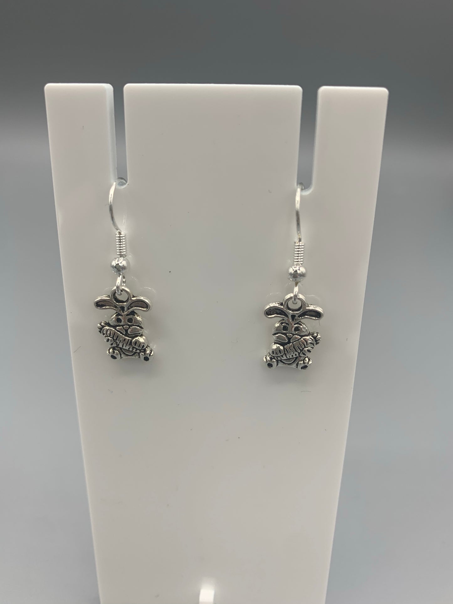 Alloy silver cartoon bunny holding oversized bunny charm on silver plated hooks earrings. easter earrings. Novelty easter earrings. Novelty earrings. Animal earrings.
