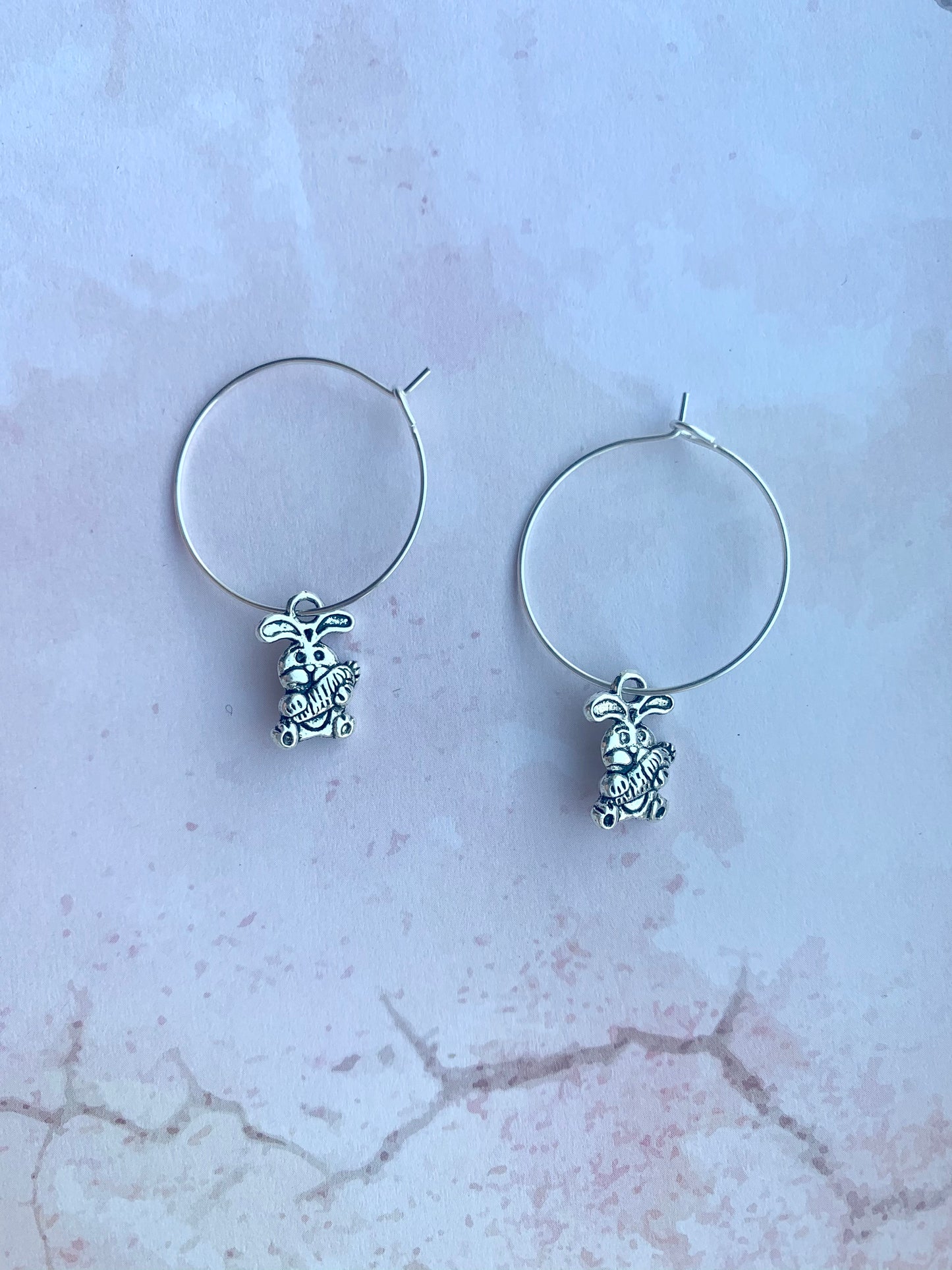 Alloy silver cartoon bunny holding oversized bunny charm on silver plated hoop earrings. easter earrings. Novelty easter earrings. Novelty earrings. Animal earrings.