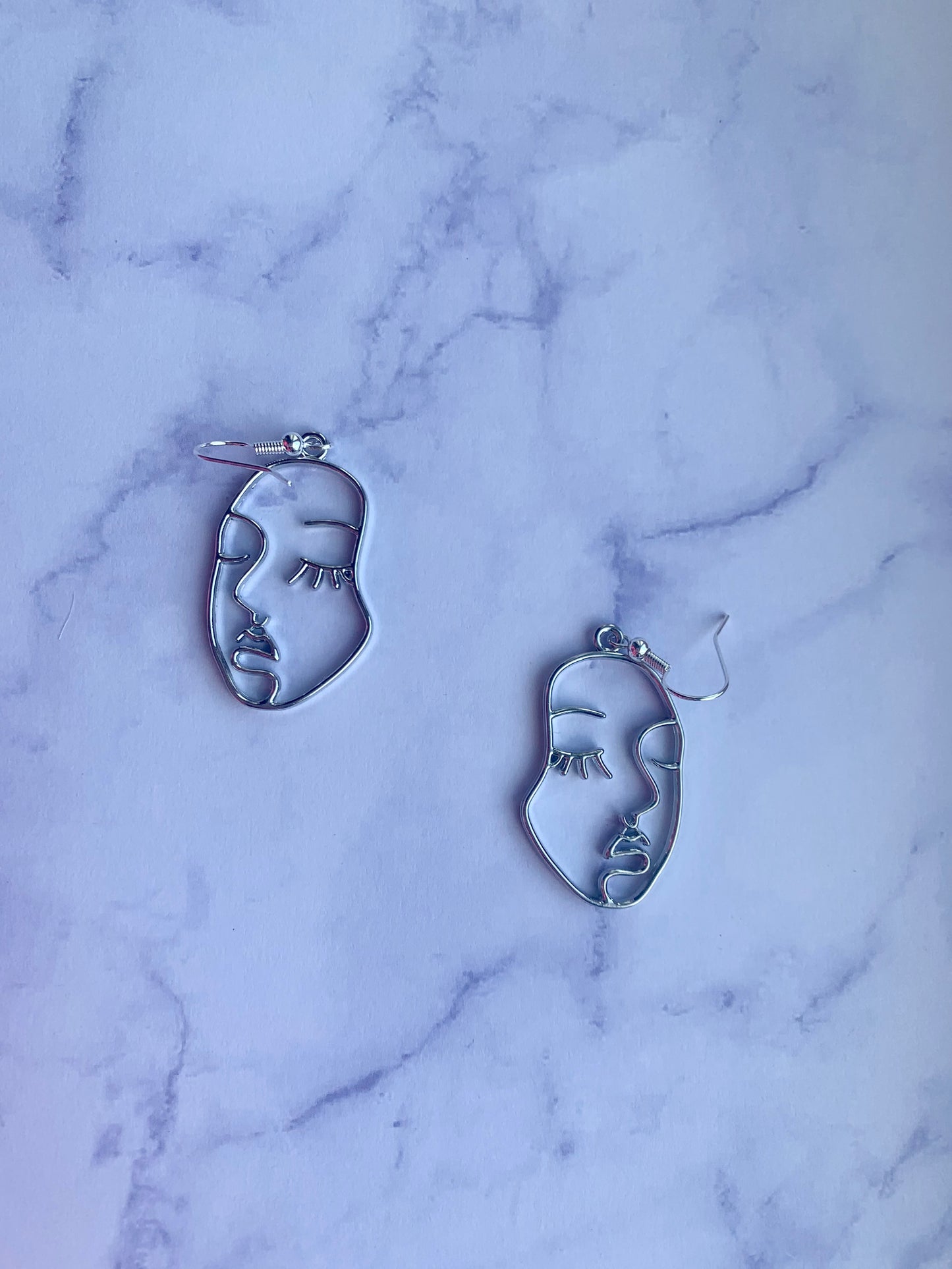 Beautiful female face outline in silver alloy metal on silver plated hooks earrings. Beautiful earrings. Earrings for women. Earrings for sale.