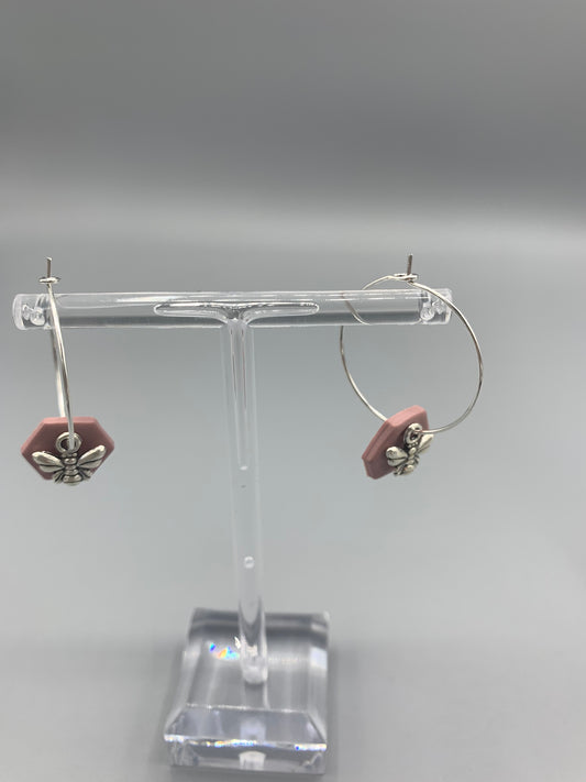 Alloy silver small bee charms on silver plated hoop earrings with an antique pink coloured fimo clay hexagonal disc behind the bee charm. 