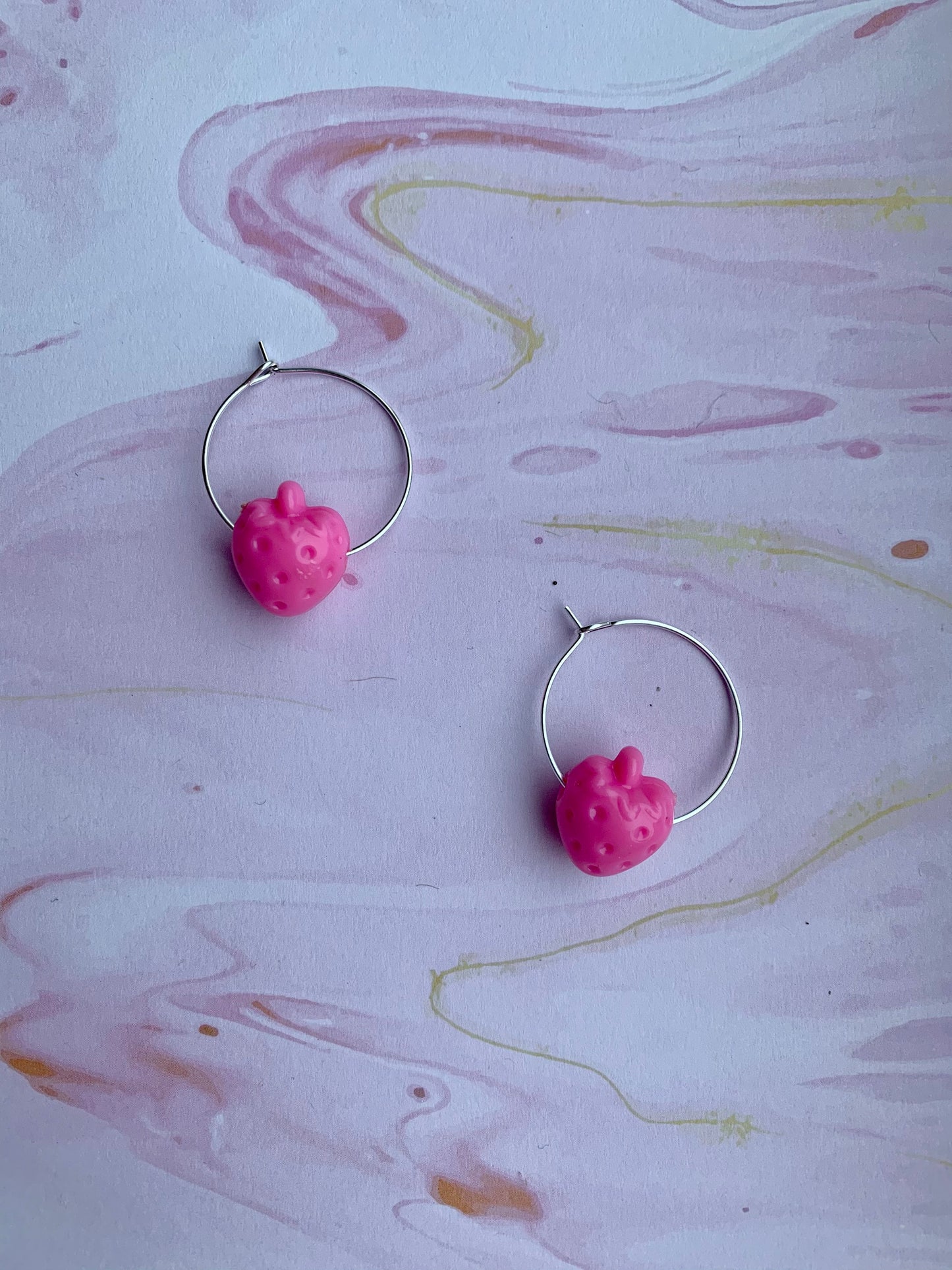 Bright pink coloured strawberry hoop earrings. food earrings