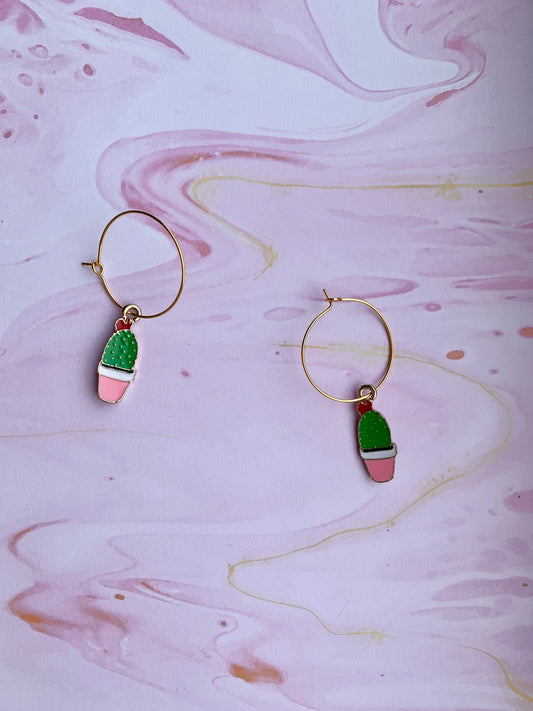 Super cute novelty cacti earrings for women. Enamel cacti charms with a pink flowerpot, red flower and green plant on gold plated hoops. Great earrings for a nature lover or plant mom. 