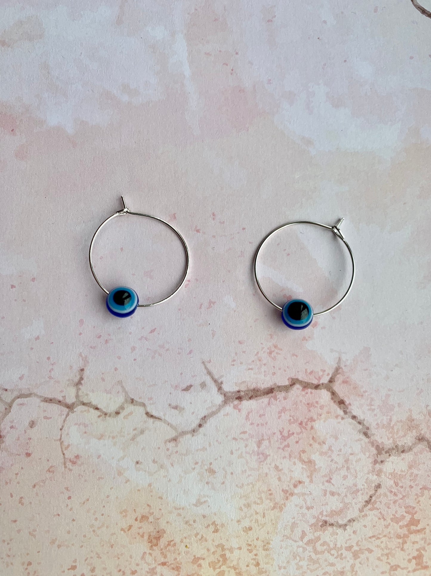 Small evil eye spherical bead on silver plated hoop earrings. Colours from outside to inside of the evil eye are dark blue, white, light blue, black. Hoop earrings. Spiritual earrings. Earrings for women. 
