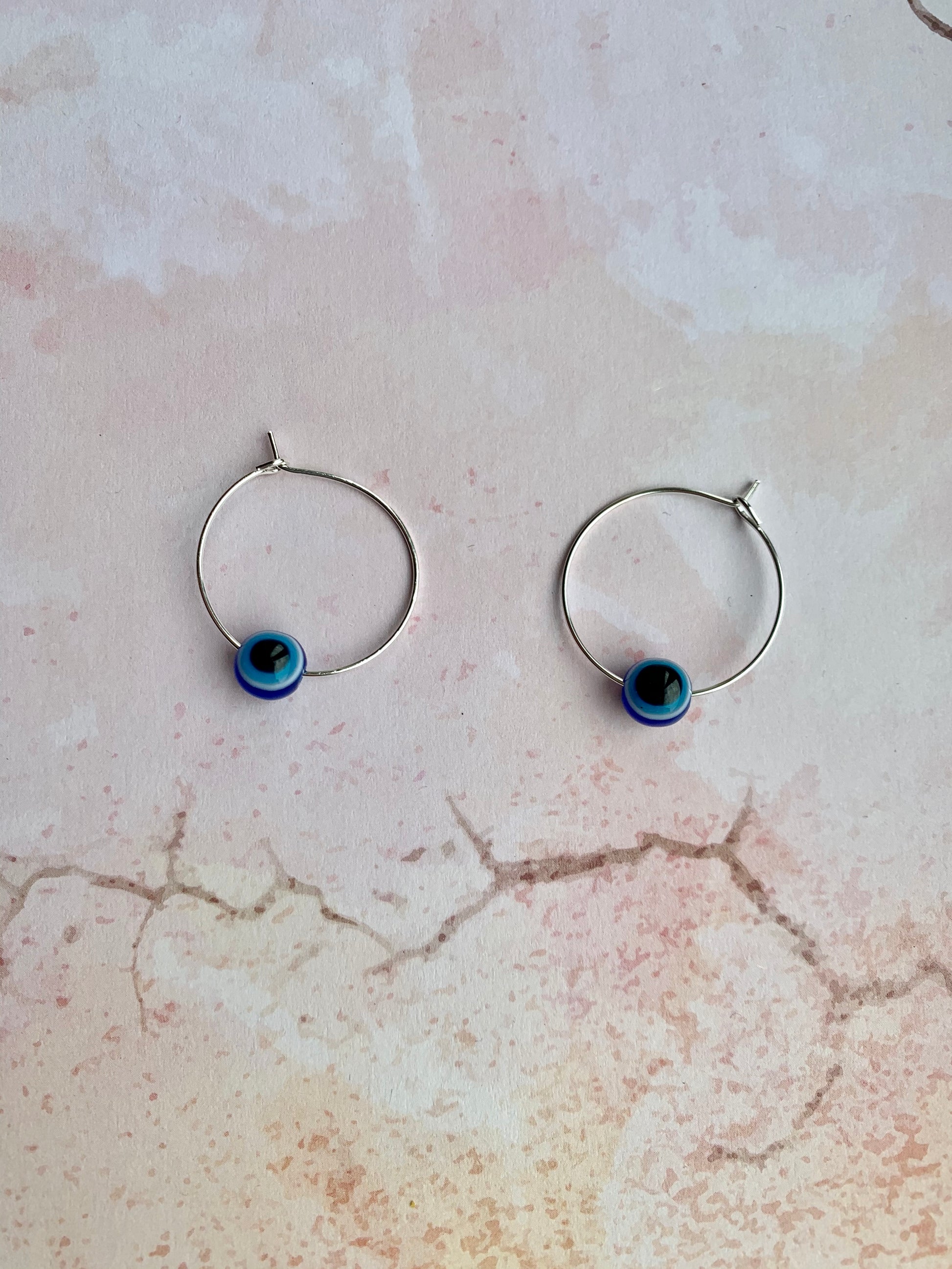 Small evil eye spherical bead on silver plated hoop earrings. Colours from outside to inside of the evil eye are dark blue, white, light blue, black. Hoop earrings. Spiritual earrings. Earrings for women. 