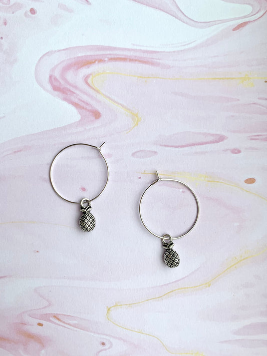 Super cute pineapple earrings. Small silver coloured pineapple charm on silver plated hoos. hoop earrings. popular earrings. cheap earrings. 