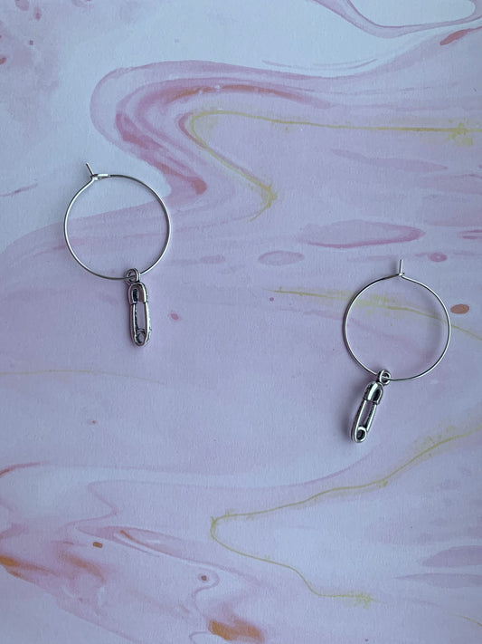 goth earrings. emo earrings. Silver coloured alloy safety pin charm on silver plated hoops. hoop earrings. funky earrings. 