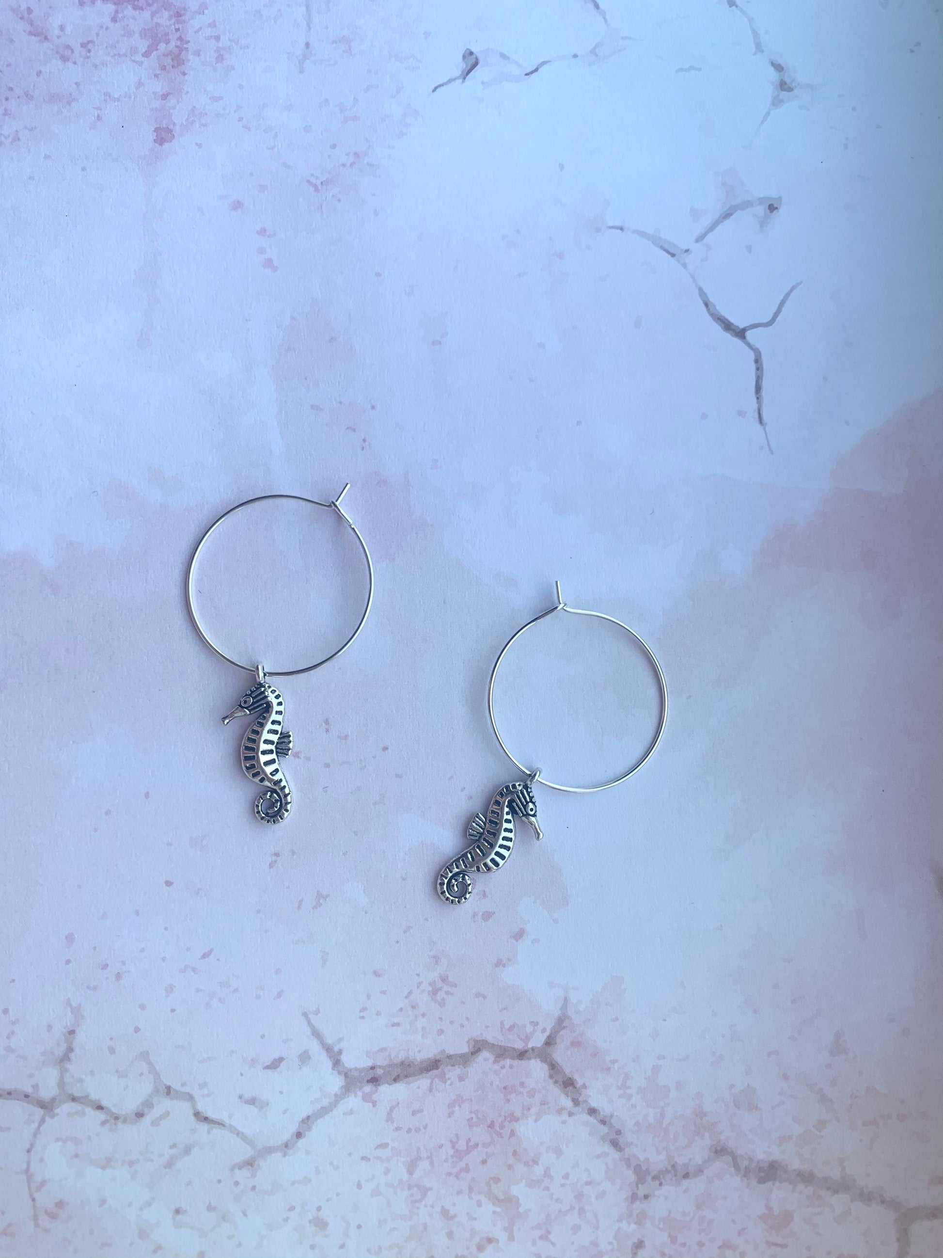 seahorse earrings. holiday earrings. Silver coloured alloy seahorse charm on silver plated hoops. hoop earrings. animal earrings. 