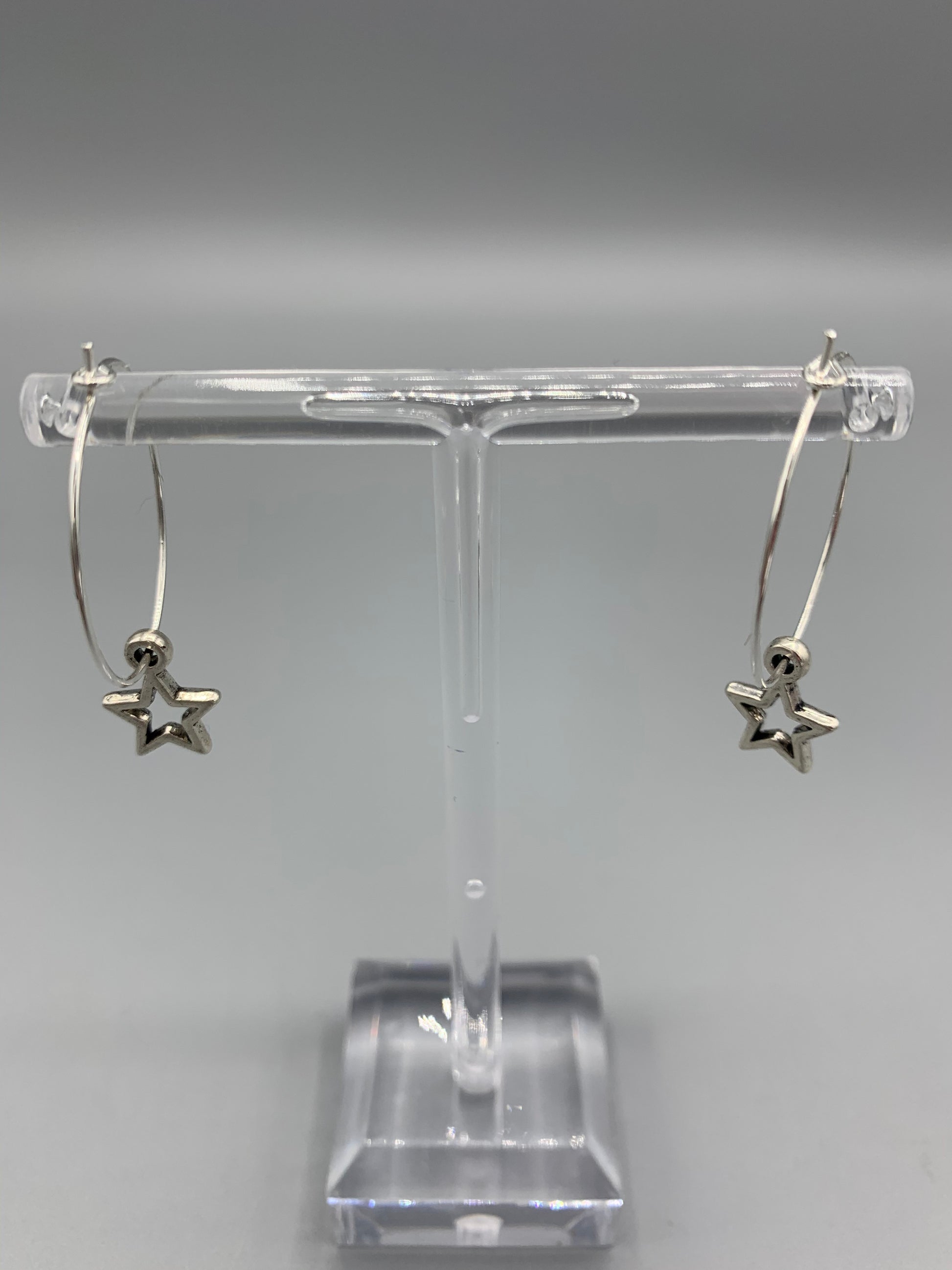 Star earrings. alloy silver coloured star hollow outline charm on silver plated hoops. pretty earrings. hoop earrings